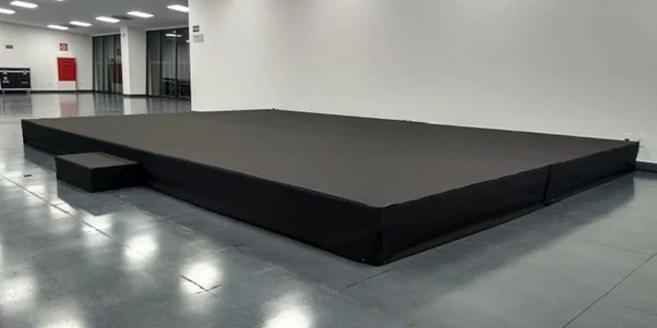 Palco modular com revestimento preto em um salão de eventos